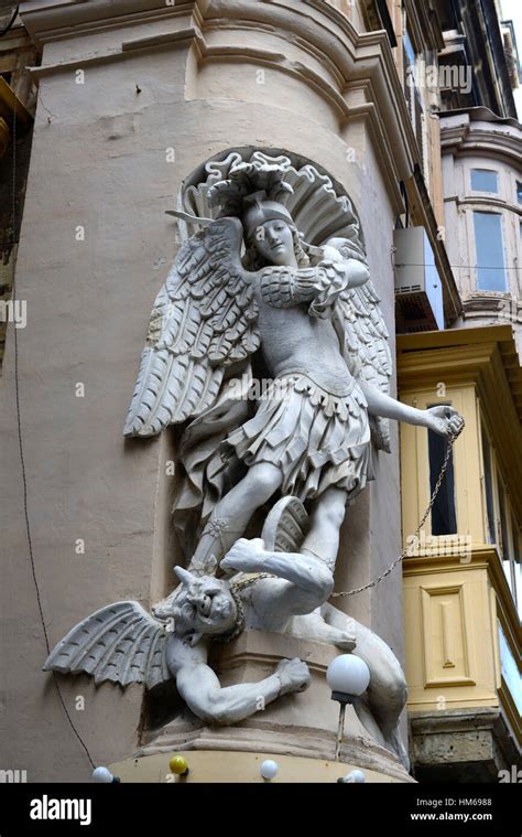 St Michael fighting satan devil statue sculpture street corner Stock ...