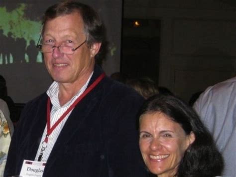 two people standing next to each other holding wine glasses