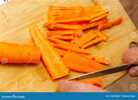 O Processo De Corte De Cenouras Uma Faca No Tabuleiro Foto De Stock