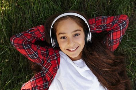 Vue De Dessus De La Souriante Jeune Fille Brune Allongée Sur Lherbe