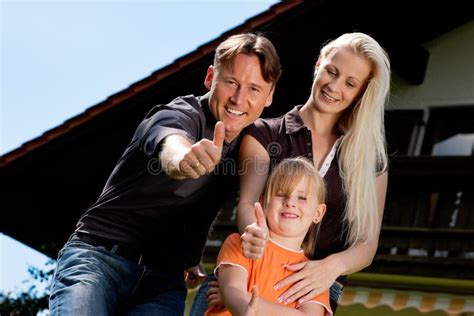 Famille S Asseyant Devant Leur Maison Photo Stock Image Du Herbe