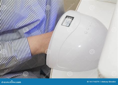 Woman Is Drying Her Nails In A Uv Lamp In A Nail Salon Stock Image