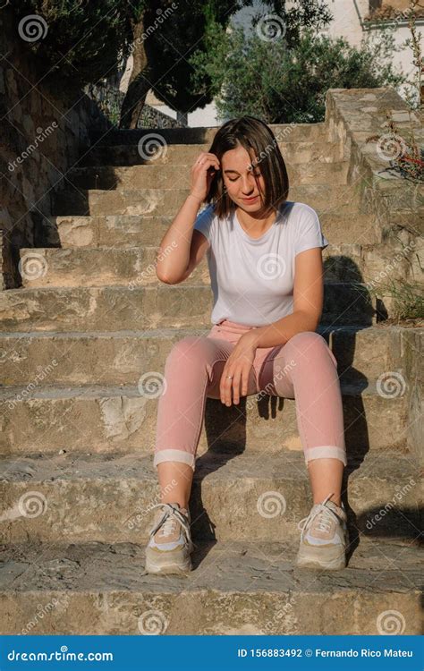 Portrait D Une Jeune Jolie Fille Assise Sur Un Escalier Touchant Ses