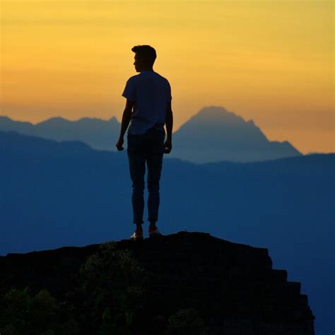 Premium Photo Rear View Of Man Standing On Cliff Against Sky