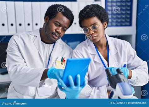 African American Man And Woman Scientists Using Touchpad Working At