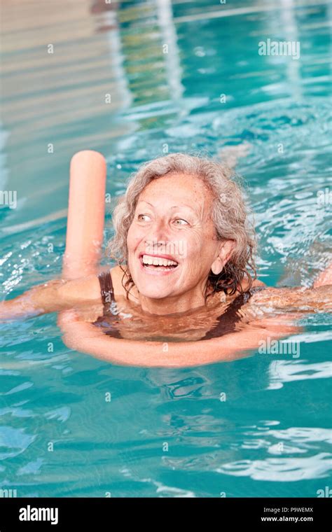 Vital Senior Woman Is Learning To Swim With Swimming Noodle In The