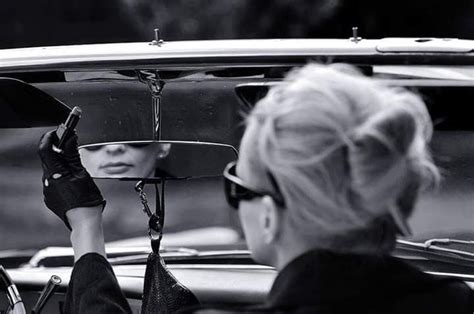 A Woman Sitting In The Driver S Seat Of A Car With An Umbrella Over Her