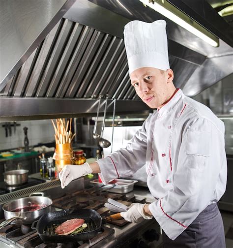 Chef En La Cocina Del Restaurante En La Estufa Con Pan Cocina Foto