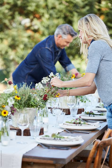 Mature Couple Setting The Table For A Farm To Table Dinner Party Del