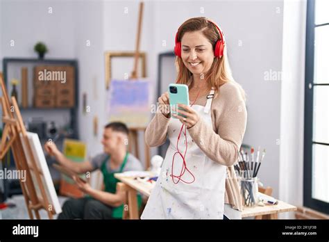 Man and woman artists listening to music drawing at art studio Stock Photo - Alamy