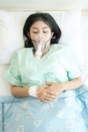 Young Woman In Hospital Bed With Oxygen Mask