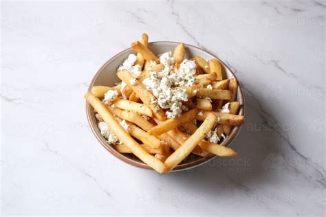 Image of Bowl of hot chips with sprinkled feta cheese - Austockphoto