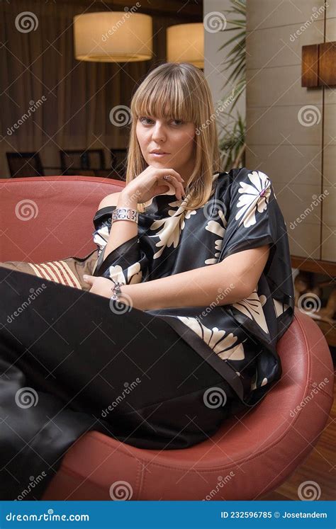 Femme Assise Dans Un Fauteuil Dans Le Salon De Sa Maison Image Stock