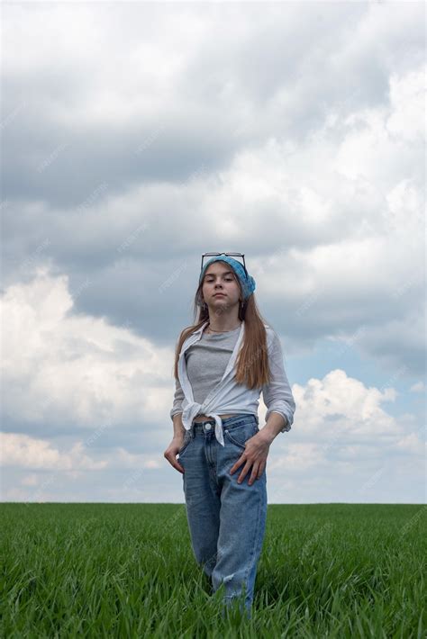 Retrato De Una Pequeña Adolescente En Un Campo De Hierba Verde Con El Telón De Fondo De Un