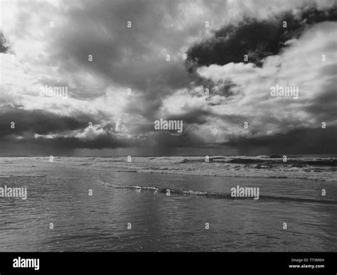 Stormy Weather Dark Storm Clouds Reflected On The Water At The Beach