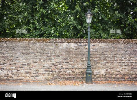 Lamp post street on brick wall background Stock Photo - Alamy