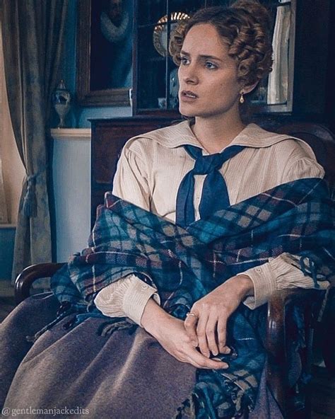 A Woman Sitting In A Chair Wearing A Plaid Scarf