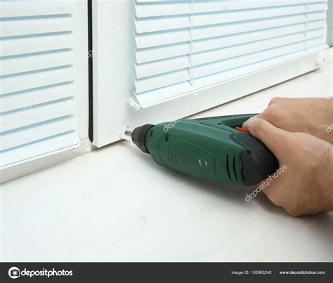 Man installing window shades Stock Photo by ©belchonock 155963240