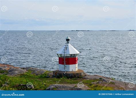 Lighthouse On A Rocky Shore With The Sea In The Background Stock Photo