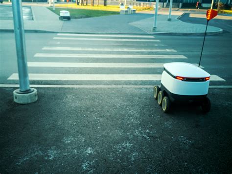 Delivery robots queue patiently to use pedestrian crossing in Cambridge