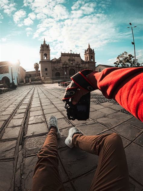 Man Sitting on the Sidewalk and Taking a Picture of the Ayacucho Cathedral, Peru · Free Stock Photo