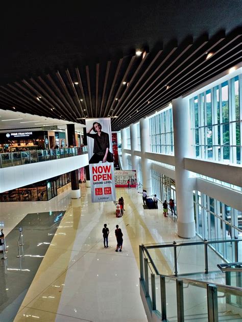 An Empty Mall With People Walking Around And Signs Hanging From The