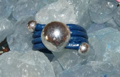 A Blue And Silver Ring Sitting On Top Of Some Ice Crystals With Two