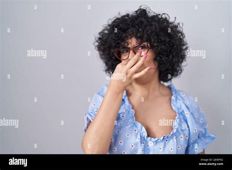 Young Brunette Woman With Curly Hair Wearing Glasses Over Isolated