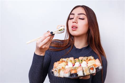 Jeune Belle Femme Mangeant Les Sushi Pousse De Studio Sur Le Backgr