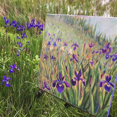 An Easel Sitting In The Grass With Purple Flowers