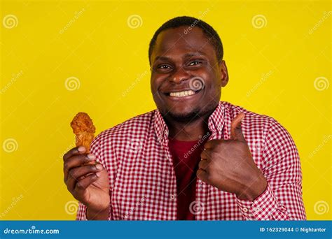 Funny African American Man Eating Fried Chicken Leg in Studio Yellow ...