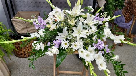 An incredible casket spray with white lilies, purple stock, and more by ...