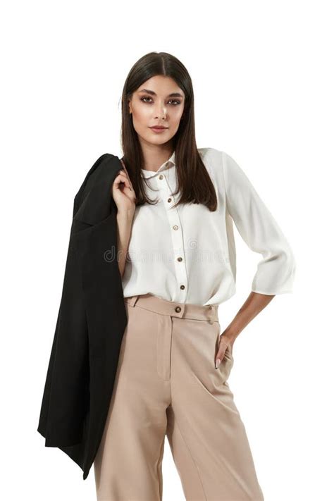 Woman In White Shirt And Beige Pants Holding Black Blazer Stock Photo