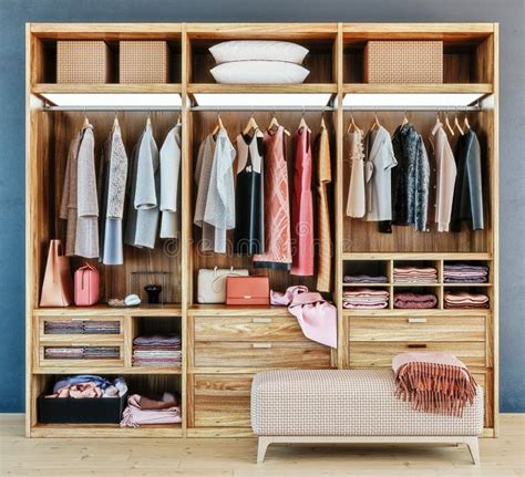 Modern Wooden Wardrobe With Clothes Hanging On Rail In Walk In Closet