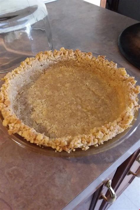 An Uncooked Pie Sitting On Top Of A Counter Next To A Wine Glass