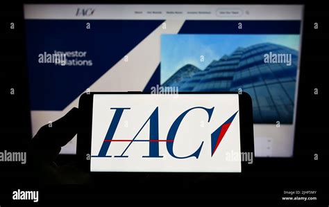 Person Holding Smartphone With Logo Of US Media Company IAC