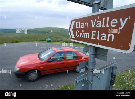 Red Car Driving On Road Elan Valley Near Rhayader Powys Mid Wales A