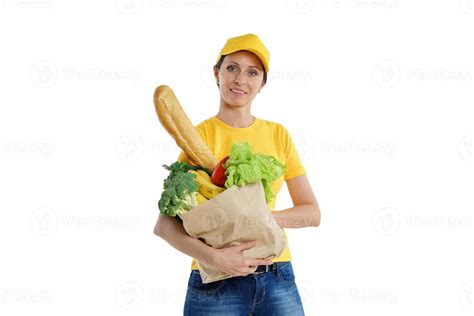 Smiley delivery woman in yellow posing with grocery bag, white ...