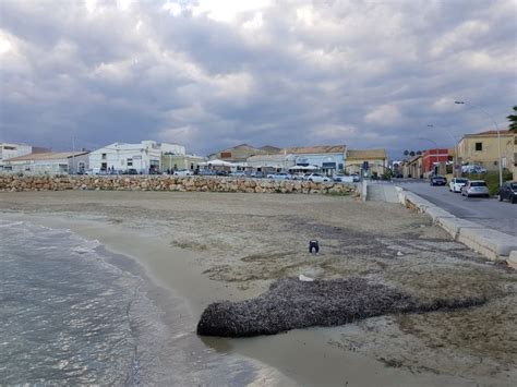 The Beach Is Covered In Sand And Water Next To Buildings On Either Side