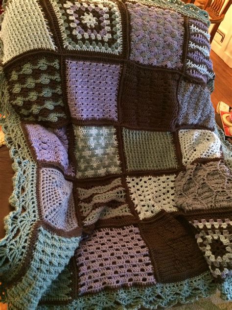 A Crocheted Blanket Sitting On Top Of A Wooden Table Next To A Chair