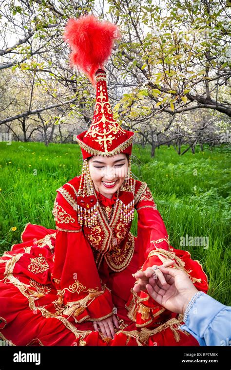 Happy Woman In Kazakh Red Costume With Wedding Ring Present Of Her