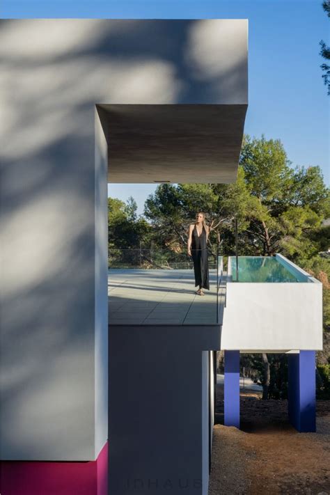 A Woman Standing On The Side Of A Building With A Pool In Front Of Her