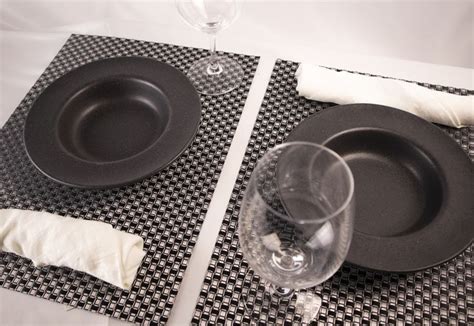 Black And White Placemats On White Table With Clear Wine Glasses On Top