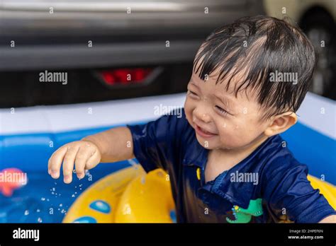 Adorable Baby Boy Happy And Enjoying Playing Water On Mini Pool Stock