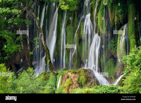 Crystal Clear Pure Water Rushing Down Mossy Rocks Into A Beautiful Azure Colored Lake At The