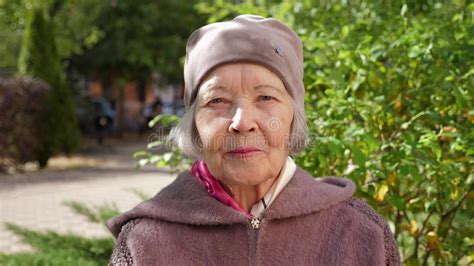 Portrait Of An Elderly Grandmother In A Hat In The Park In Autumn On A