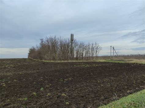 Agricultural Field Electric Poles And Water Tower In Winter Stock Photo