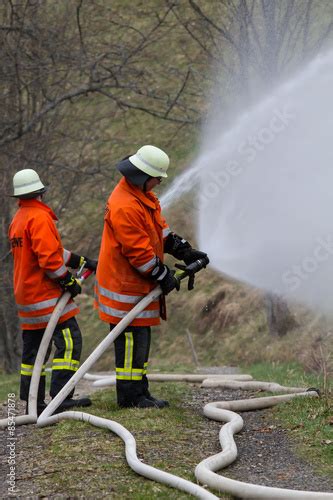 Feuerwehr beim Löschen Stock Foto Adobe Stock