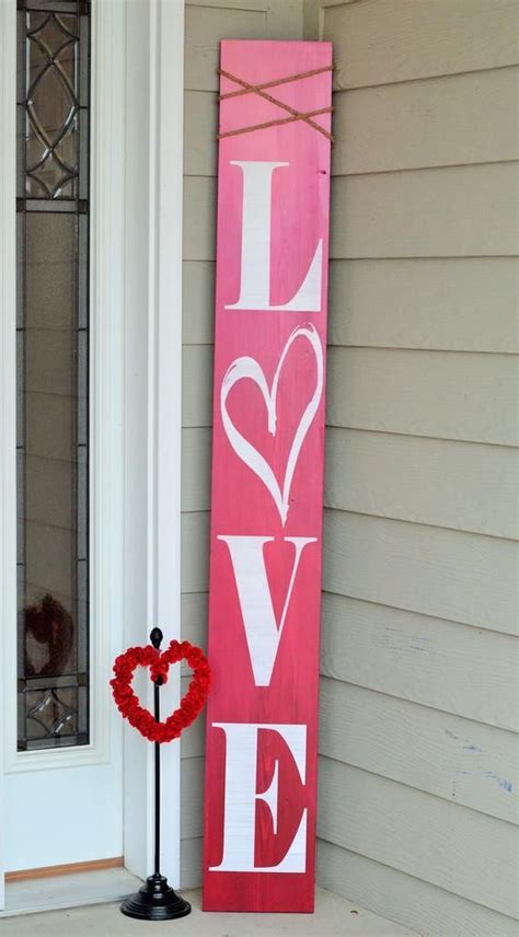 A Red Love Sign Sitting On The Front Porch Next To A Wreath And A Heart