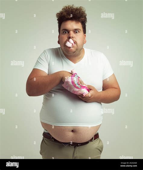 Must Have More Marshmallows Shot Of An Overweight Man With Marshmallows Shoved In His Mouth